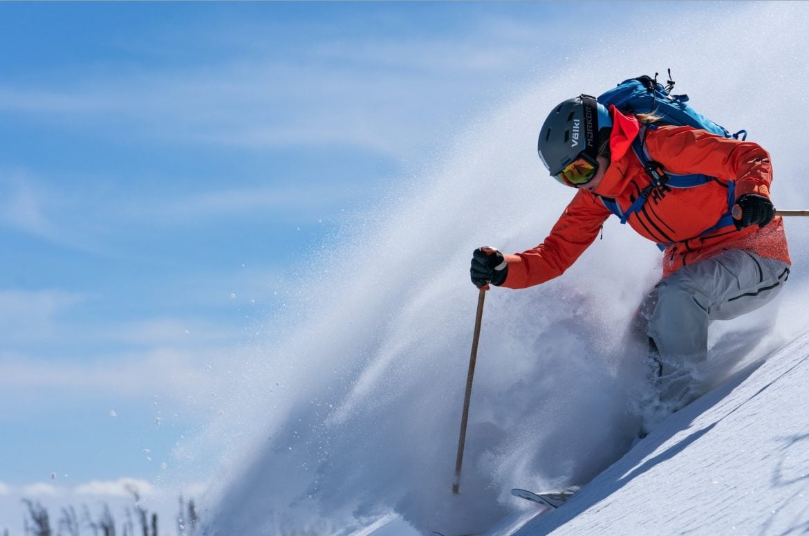 helly hansen man skiing down mountain in extreme weather snow